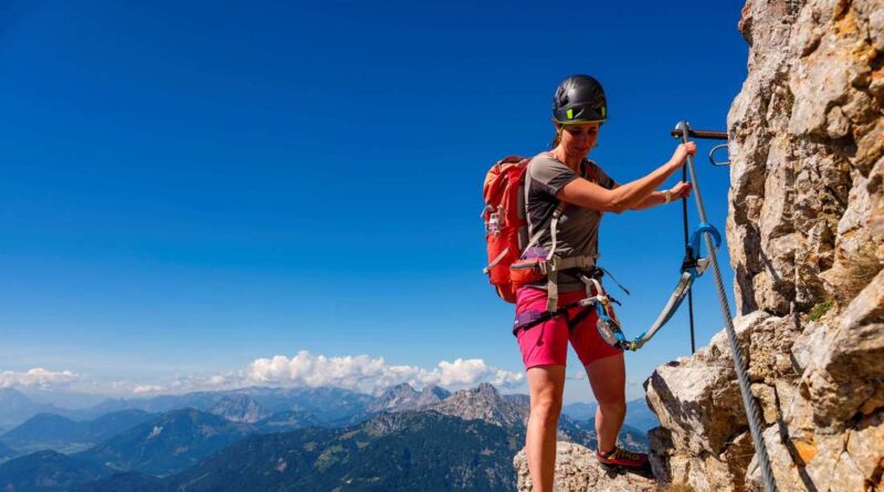 A woman walks via ferrata or via ferrata in Großer Buchstein, Gesäuse National Park, Admont, Styria, Austria