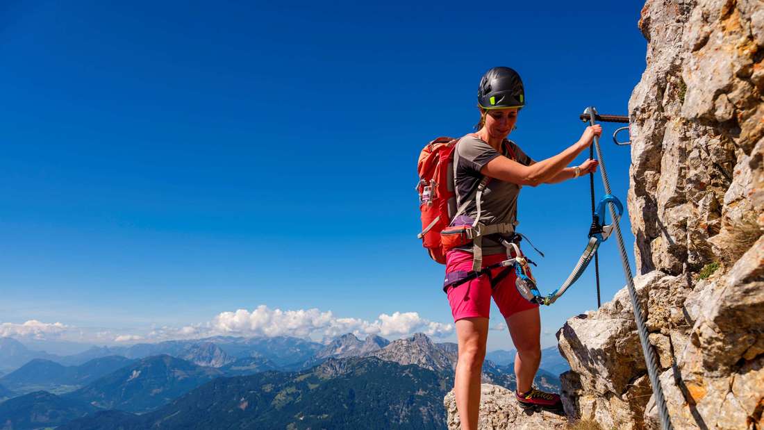 A woman walks via ferrata or via ferrata in Großer Buchstein, Gesäuse National Park, Admont, Styria, Austria