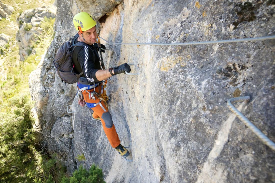 A man walks a via ferrata in Spain.